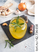 Homemade beef bone and vegetable broth with turmeric seasoning in a glass jar for storage and carrying. Healthy food with collagen and amino acids. Copy space. Стоковое фото, фотограф Глущенко Елена / Фотобанк Лори