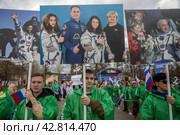 Участники космического шествия держат плакаты с портретами российских космонавтов во время празднования Дня космонавтики 12 апреля на ВДНХ в городе Москве, Россия (2024 год). Редакционное фото, фотограф Николай Винокуров / Фотобанк Лори