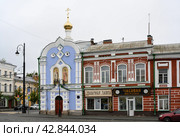 RYBINSK, RUSSIA - AUGUST 20, 2023. The chapel at the Yugsky farmstead in Rybinsk, Russia, next to shops and signs in the style of the 19th century: 'Tobacco Shop' and 'Watch Workshop' Редакционное фото, фотограф Сергей Фролов / Фотобанк Лори