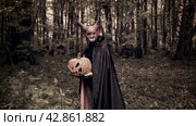 Devil with a Halloween pumpkin in his hands walks through a dark forest. Man in a scary mask. Стоковое видео, видеограф Дмитрий Кобзев / Фотобанк Лори