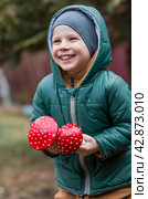 A child and a fly agaric. The boy with the fly agaric. A dangerous poisonous mushroom in the hands of a child. Mushroom poisoning, microdosing, eating herbal medicine. Стоковое фото, фотограф Photojuli / Фотобанк Лори