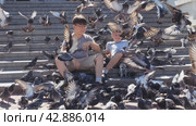 A child surrounded by pigeons. Boys feed birds. The delight of children from communicating with wildlife. Стоковое видео, видеограф Константин Мерцалов / Фотобанк Лори