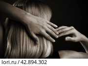 Женщина с длинными волосами стоит спиной к зрителю и сцепляет руки в замок. Стоковое фото, фотограф Pukhov K / Фотобанк Лори