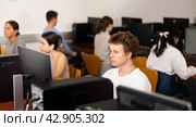 Positive male student using PC and studying computer science in the classroom. Стоковое фото, фотограф Яков Филимонов / Фотобанк Лори