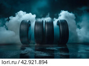 Автомобильные шины в темном дымном помещении, освещенные рисующим светом. Стоковое AI-изображение, AI-художник Максим Коломыченко / Фотобанк Лори