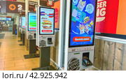 Moscow April 10 2024, self-service checkouts for ordering and paying for orders in a fast food restaurant. Indoor Burger king. Fast food restaurant and self-service checkouts. Редакционное фото, фотограф Скрипачев Антон / Фотобанк Лори