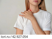 Woman with pain in shoulder, upper arm. Human body health problem banner. Female person is enduring awful ache. Upset lady with muscle, nerve pain symptoms holding a hand on painful zone injured point. Стоковое AI-изображение, AI-художник Марина Демидюк / Фотобанк Лори