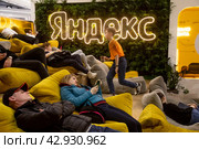 Посетители отдыхают на стенде компании "Яндекс" в павильоне выставки во время проведения Международной выставки-форума "Россия" на территории выставочного комплекса ВДНХ в городе Москве, Россия (2024 год). Редакционное фото, фотограф Николай Винокуров / Фотобанк Лори