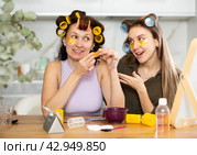 Two women curl their hair with curlers and use patches. Стоковое фото, фотограф Яков Филимонов / Фотобанк Лори