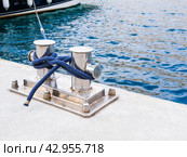 Knecht anchorage on a marina with a blue rope tied. Copy space, close up. Стоковое фото, фотограф Александр Довянский / Фотобанк Лори