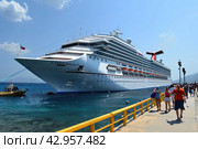 A large tourist white cruise ship is moored to the pier. The greeters are expected to meet. Стоковое AI-изображение, AI-художник Ярославский Максим / Фотобанк Лори