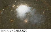 Teen ignites firecracker on pavement. Стоковое видео, видеограф Данил Руденко / Фотобанк Лори