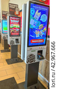 Moscow April 10 2024, self-service checkouts for ordering and paying for orders in a fast food restaurant. Indoor Burger king. Fast food restaurant and self-service checkouts. Редакционное фото, фотограф Скрипачев Антон / Фотобанк Лори