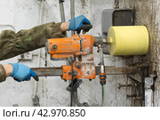 Worker using an electric drill to make a hole in a concrete wall, closeup. Стоковое фото, фотограф Nobilior / Фотобанк Лори