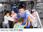 Children restraining boy trying to reach out something in escape room. Стоковое фото, фотограф Яков Филимонов / Фотобанк Лори