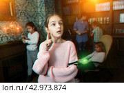 Pensive tween girl solving riddles in quest room, toned image. Стоковое фото, фотограф Яков Филимонов / Фотобанк Лори