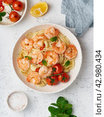 Pasta bavette with fried shrimps, bechamel sauce, mint leaf, garlic, on white plate, top view. Стоковое фото, фотограф Natalia Gdovskaia / Фотобанк Лори