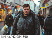 Крупный молодой человек идет по улице города. Стоковое AI-изображение, AI-художник Щеголева Ольга / Фотобанк Лори