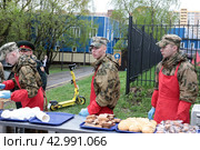Солдаты срочной службы раздают хлеб на акции высадки деревьев в городском парке Реутова (2024 год). Редакционное фото, фотограф Дмитрий Неумоин / Фотобанк Лори