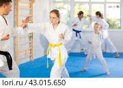 Teen girl is paired with male teacher to learn how to strike and rehearses blocking opponent. Стоковое фото, фотограф Яков Филимонов / Фотобанк Лори