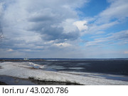 Petrozavodsk, Russia, 04.26.2024: Lake Onega is a lake in northwestern Russia, Republic of Karelia. It belongs to the basin of Baltic Sea. Ice melting in early spring. Port and ship in the distance. Редакционное фото, фотограф Юлия Петровская / Фотобанк Лори