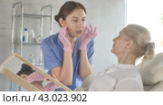 Old woman patient lying on clinical chair discussing face aesthetic procedures with doctor. Стоковое видео, видеограф Яков Филимонов / Фотобанк Лори