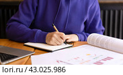Woman's hands writing notes with pen in notebook, books and textbooks on table. Стоковое фото, фотограф Alexandra Aleroewa / Фотобанк Лори