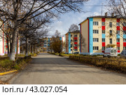 Село Клёпка, Магаданская область, Россия. Вид на улицу и красочные здания в северном посёлке. Осенний сезон. Сентябрь. Опавшие листья на дороге. Путешествие в Сибирь и на Дальний Восток России. Редакционное фото, фотограф Андрей Степанов / Фотобанк Лори