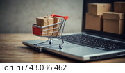 Online trading. The concept.A shopping cart and a laptop. Стоковое AI-изображение, AI-художник Александр Поташев / Фотобанк Лори
