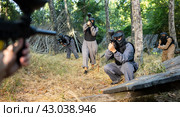 Impudent teams facing on battlefield in outdoor paintball arena during match. Стоковое фото, фотограф Яков Филимонов / Фотобанк Лори