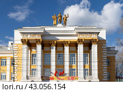 Дом офицеров, город Чита, Забайкальский край, Россия. Красивое здание в стиле «Сталинского неоклассицизма». На крыше здания скульптуры крестьянки, солдата и рабочего. На фасаде баннер с надписью «9 мая - День Победы!». (2023 год). Редакционное фото, фотограф Андрей Степанов / Фотобанк Лори