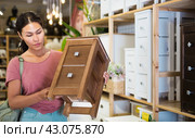 Woman choosing bedside table in store. Стоковое фото, фотограф Яков Филимонов / Фотобанк Лори
