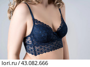 Blonde woman in blue push up bra on gray background, decollete area care. Стоковое фото, фотограф Станислав Тарко / Фотобанк Лори