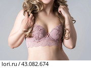 Blonde woman in pink push up bra on gray background, decollete area care. Стоковое фото, фотограф Станислав Тарко / Фотобанк Лори