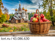 The concept of the Russian Orthodox holiday yablochny spas. A beautiful wicker basket made of vines with red ripe apples on the background of an Orthodox church. Стоковое AI-изображение, AI-художник Photojuli / Фотобанк Лори