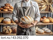Fresh delicious bread in the hands of a male baker in close-up. Freshly baked sourdough bread with a golden crust on a wooden board. The context of a bakery with delicious bread. Confectionery products. Стоковое AI-изображение, AI-художник Photojuli / Фотобанк Лори