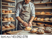 Fresh delicious bread in the hands of a male baker in close-up. Freshly baked sourdough bread with a golden crust on a wooden board. The context of a bakery with delicious bread. Confectionery products. Стоковое AI-изображение, AI-художник Photojuli / Фотобанк Лори
