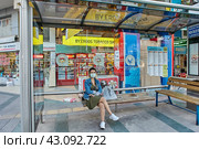 Coronavirus curfew in Antalya, young woman wearing protective face mask sits at bus stop. Стоковое фото, фотограф Владимир Григорьев / Фотобанк Лори