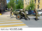 Артиллеристы салютного дивизиона катят вручную по улице 76мм дивизионную пушку ЗИС-3. Волгоград, улица Мира, Россия (2024 год). Редакционное фото, фотограф Андрей Цыганков / Фотобанк Лори