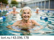 An elderly woman swims and does water aerobics in a heated pool, a happy and smiling retired woman. Recreational water sports. Стоковое AI-изображение, AI-художник Photojuli / Фотобанк Лори