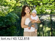 Happy mother holds child while walks in park on summer. Стоковое фото, фотограф Владимир Григорьев / Фотобанк Лори