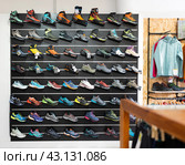 On black wooden wall of showcase - there are samples of models of hiking and climbing shoes (2023 год). Редакционное фото, фотограф Яков Филимонов / Фотобанк Лори