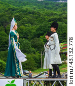 Adygea, RUSSIA - JULY 25 2015: Young Circassian girls and Adyga boys in beautiful national costumes dance against the background of a green forest. Редакционное фото, фотограф Андрей С / Фотобанк Лори