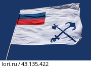 Флаг Министерства Путей Сообщения Российской Империи на фоне синего неба,  / Flag of the Russian Ministry of Railways with emblem of the Ministry, depicting crossed ax  and anchor on blue background (2018 год). Редакционное фото, фотограф Iva Noel / Фотобанк Лори