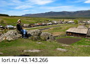 beautiful mature women sitting on a rock above the village of Tyulyuk against the backdrop of the Zigalga ridge in the Southern Urals. Стоковое фото, фотограф Акиньшин Владимир / Фотобанк Лори