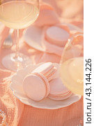 Macarons peach fuzz shade and natural pearls on a saucer. Стоковое фото, фотограф София Тюленева / Фотобанк Лори