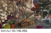 Florist carefully pours sand into the glass hexagonal container, on top of the expanded clay. The beautiful flower shop and workshop. Стоковое видео, видеограф Strunov David / Фотобанк Лори