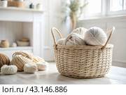 Balls of yarn in a wicker basket in white and beige tones. Needlework, textiles, knitting. Winter season, small business, handmade clothes. Стоковое AI-изображение, AI-художник Photojuli / Фотобанк Лори