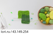 Video of hand knitting square pattern using 10-stitch method from wool yarn in different shades of green color. Spring crafts and needlework. Flat lay, top view, close-up, mock up. Стоковое видео, видеограф Виктория Катьянова / Фотобанк Лори