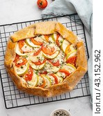 Homemade savory galette with vegetables, wholegrain pie with tomatoes, zucchini, blue cheese. Стоковое фото, фотограф Natalia Gdovskaia / Фотобанк Лори